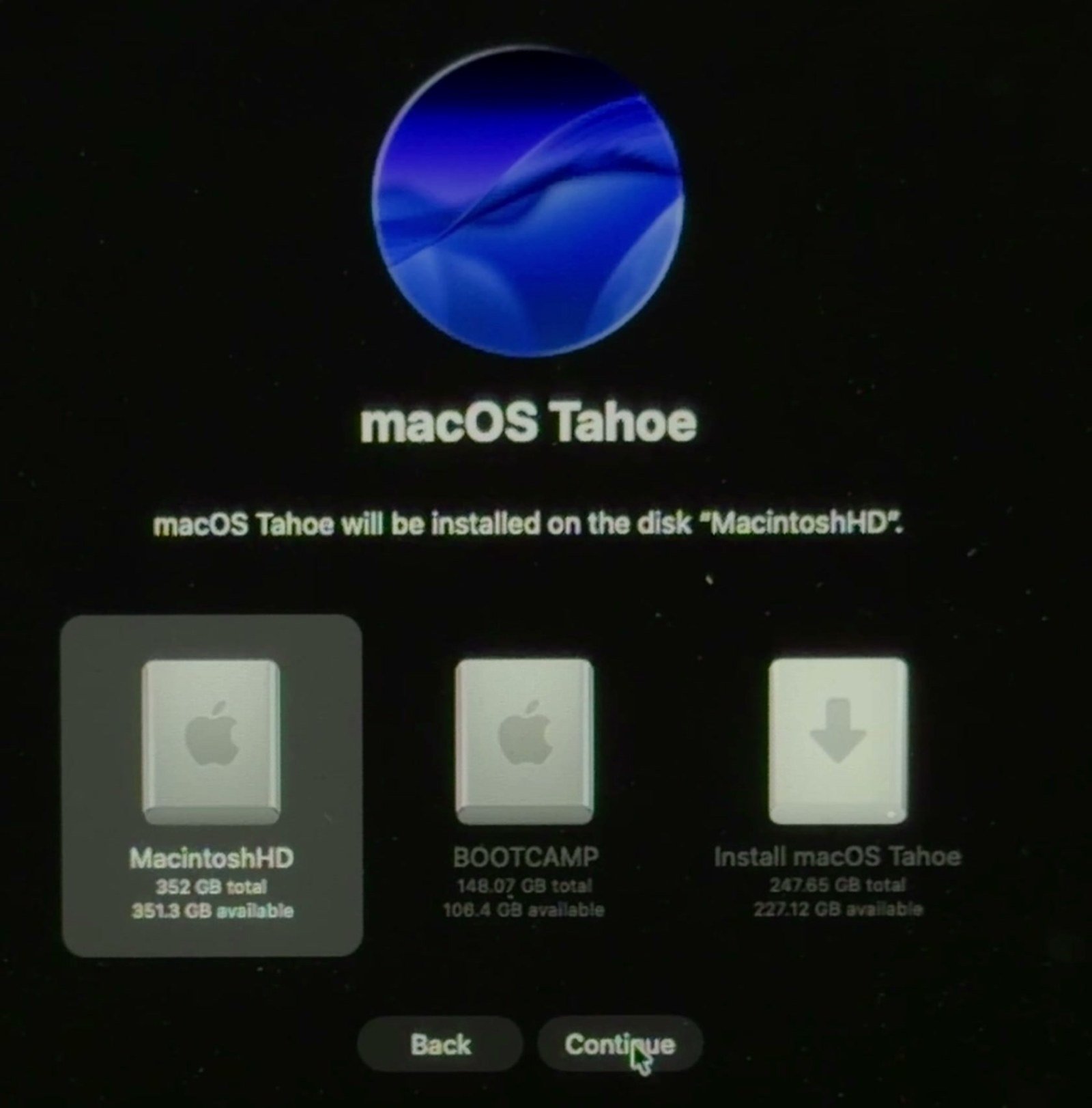 macOS Tahoe installer asking where to install, with the MacintoshHD drive selected alongside a separate BOOTCAMP partition and the USB installer.