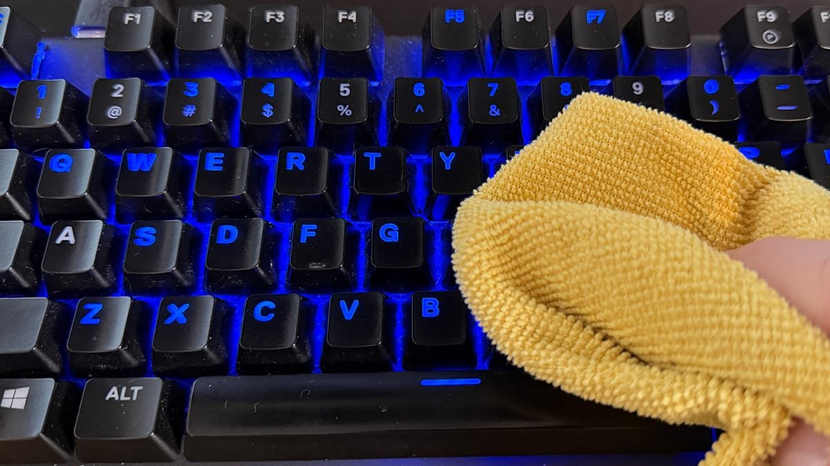 External keyboard being wiped with a microfiber cloth during a quick clean