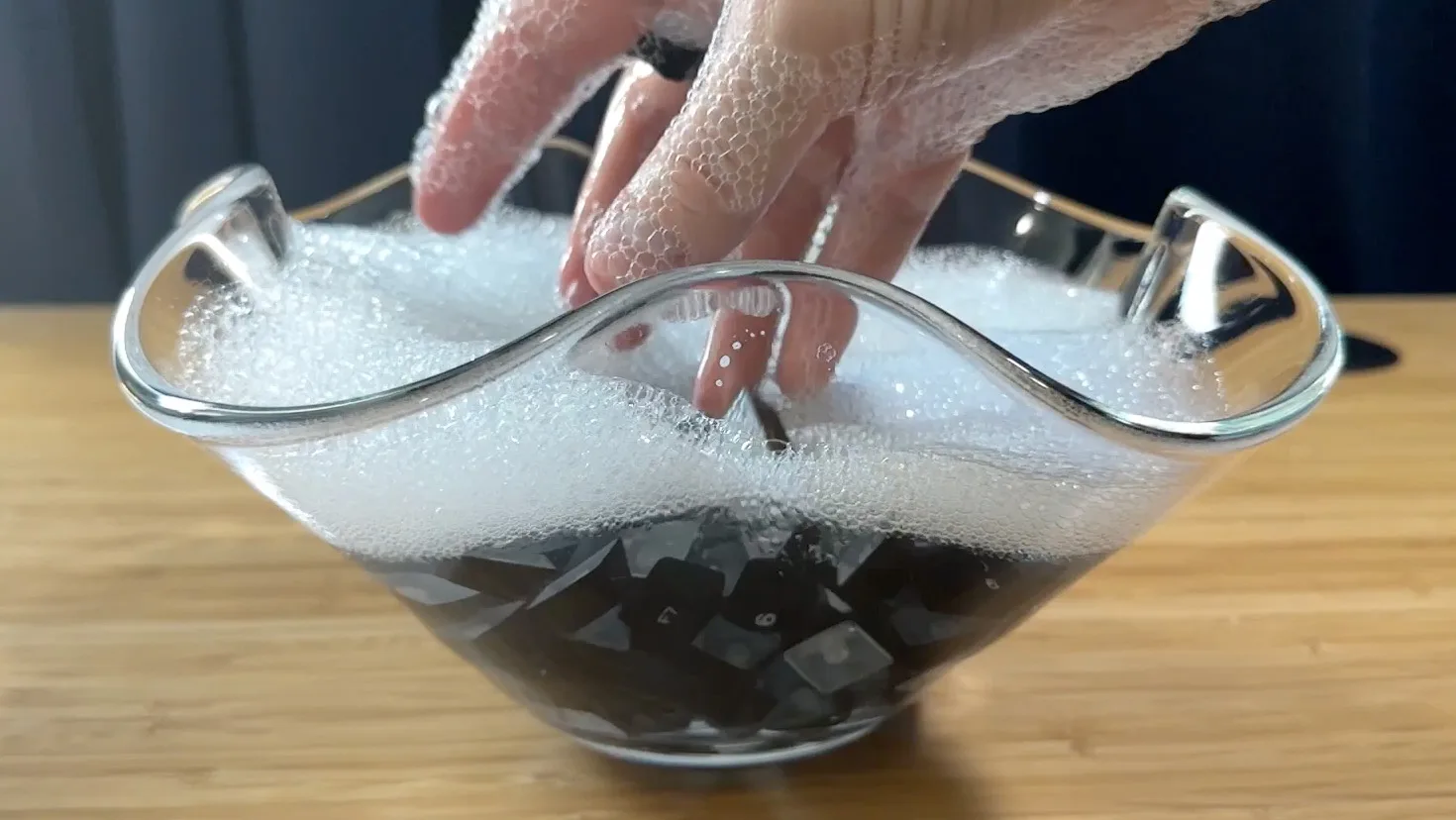 Keycaps soaking in a bowl of warm soapy water during cleaning